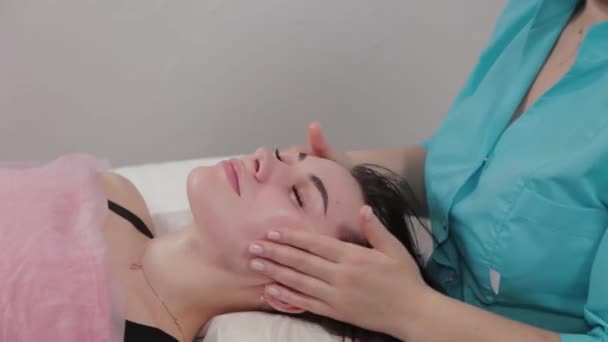 Vrouw massage therapeut voert gezichtsmassage naar de klant van de massagesalon. — Stockvideo