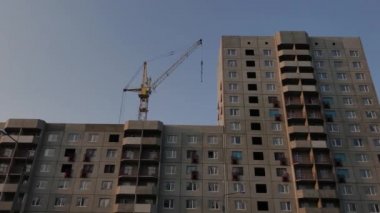 Mavi gökyüzünün arka planında vinç olan yeni ev yapım aşamasında..