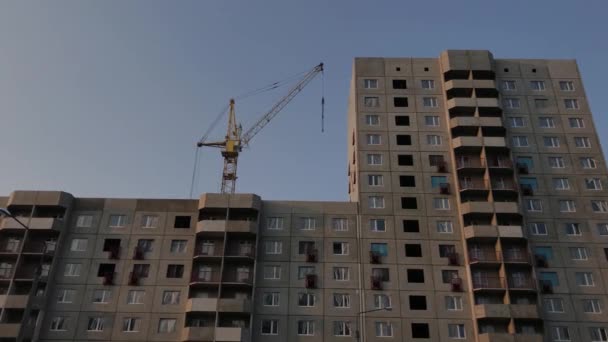 Nouvelle maison en construction avec une grue sur fond de ciel bleu . — Video