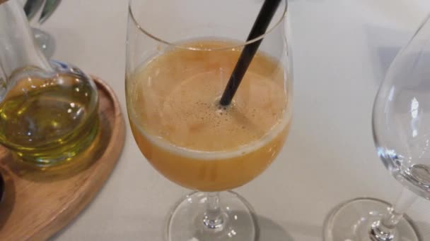 El jugo de naranja en un vaso y el aceite en una mesa en un restaurante . — Vídeo de stock