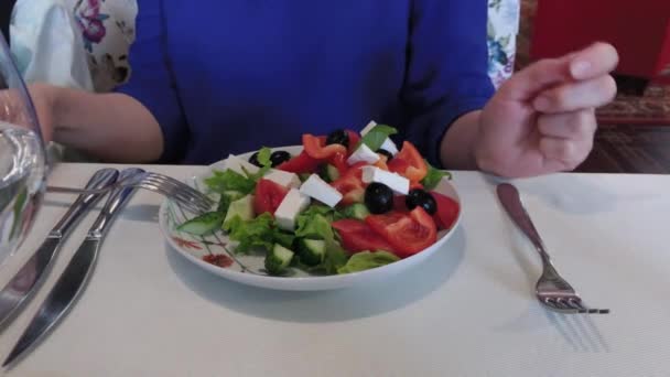 Verse smakelijke Griekse salade op een tafel in een restaurant. — Stockvideo