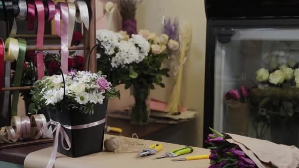 Ανθοπωλεία εργαλεία εργασίας βρίσκονται σε ένα τραπέζι με λουλούδια. — Αρχείο Βίντεο