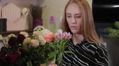 Profesyonel çiçekçi bir çiçek kompozisyonu topluyor. Uluslararası Kadınlar Günü için güzel bir buket.