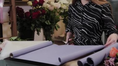 Profesyonel çiçekçi çiçekler için ambalaj hazırlar. Uluslararası Kadınlar Günü için güzel bir buket.