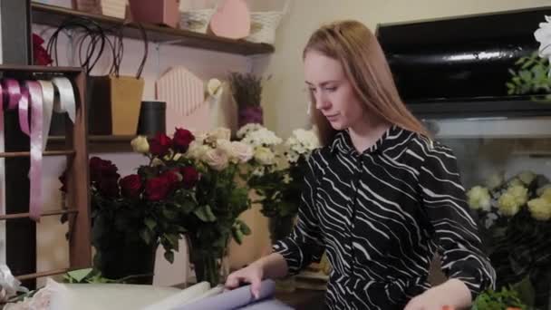 Professzionális virágárus készíti a csomagolást a virágok számára. Gyönyörű csokor a Nemzetközi Nőnapra. — Stock videók