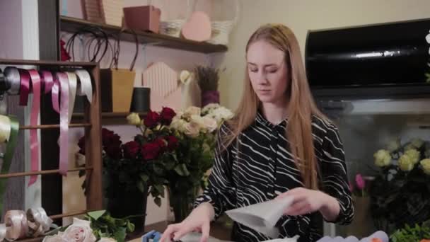 Florista profesional prepara el embalaje para las flores. Hermoso ramo para el Día Internacional de la Mujer . — Vídeos de Stock