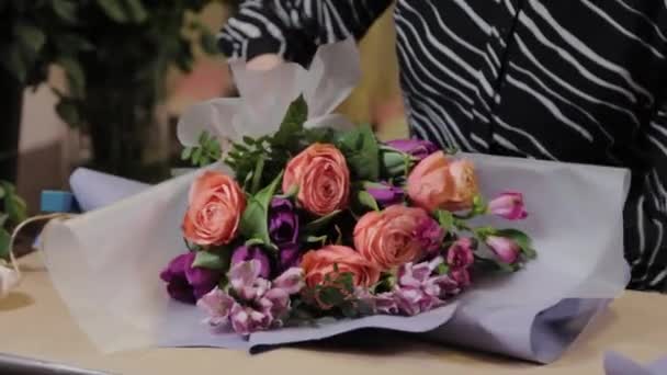 Professionele bloemist is het inpakken van een boeket. Mooi boeket voor Internationale Vrouwendag. — Stockvideo