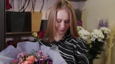 Elinde satılık bir buketi olan profesyonel bir çiçekçi. Uluslararası Kadınlar Günü için güzel bir buket.