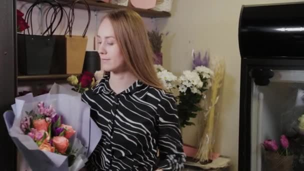 Profesjonalna kwiaciarnia wiąże bukiet z jedwabną wstążką. Piękny bukiet na Międzynarodowy Dzień Kobiet. — Wideo stockowe