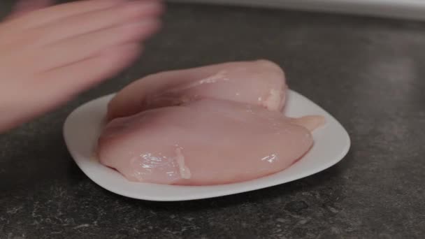 Boy touches chicken breast on a plate. — Stock Video