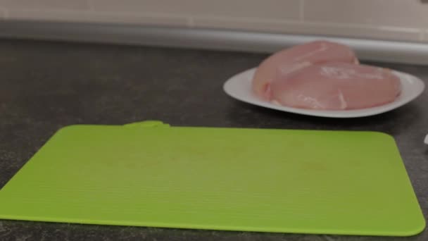 L'uomo mette il petto di pollo su un tagliere . — Video Stock