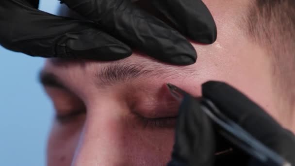 Брови выщипывают брови мужчине в салоне красоты . — стоковое видео