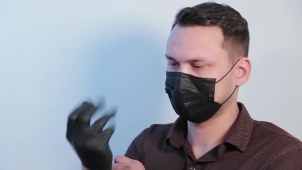 Jeune homme met des gants en caoutchouc sur ses mains . — Video