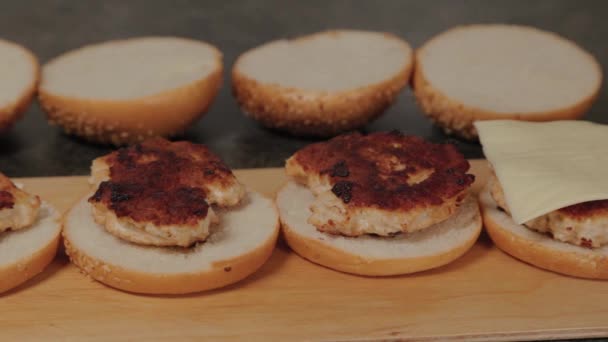 L'uomo mette il formaggio sugli hamburger. — Video Stock