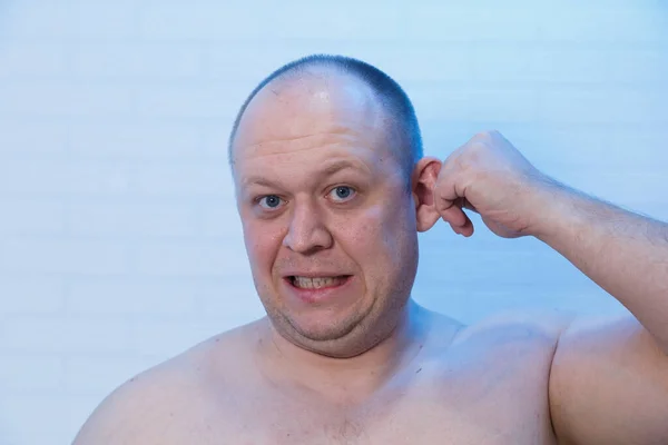 Retrato de um homem careca que segura a orelha . — Fotografia de Stock