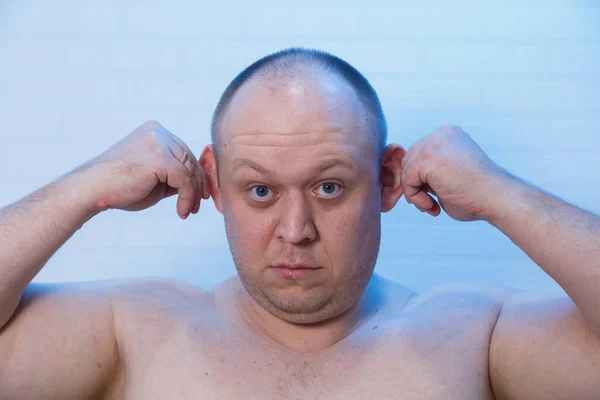 Egy kopasz férfi portréja, aki fogja a fülét.. — Stock Fotó