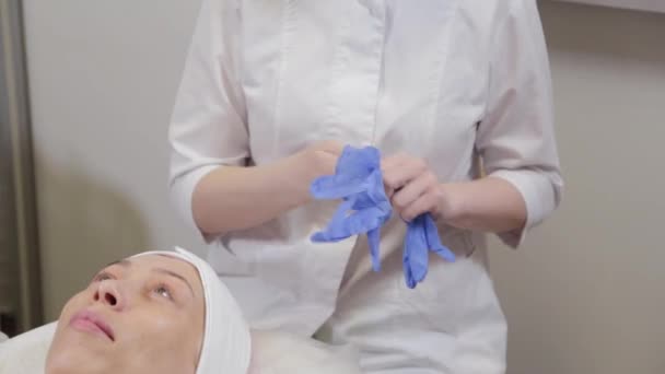 Επαγγελματική beautician βάζει σε ελαστικά γάντια πριν από τη διαδικασία. — Αρχείο Βίντεο