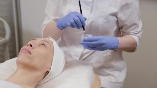 Um esteticista profissional mistura uma máscara facial em um recipiente especial. — Vídeo de Stock