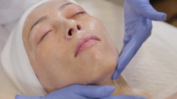 Un'estetista professionista fa massaggi facciali a una donna. Cosmetologia . — Video Stock