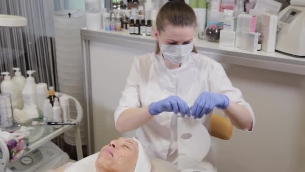 Le professionnel déballe le masque facial en papier. Cosmétologie . — Video