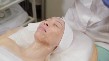 Profesyonel kadın müşteriye yüz maskesi takar. Kozmetoloji.