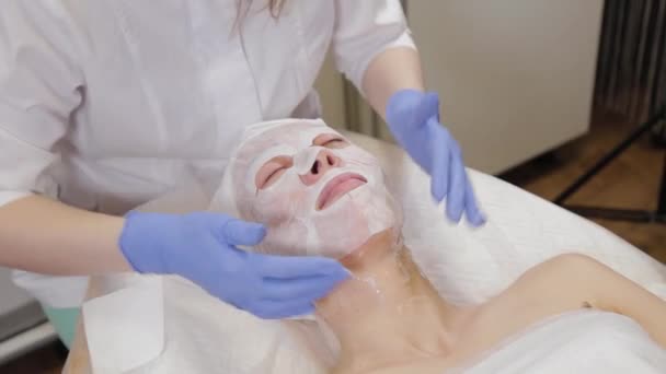 Professionista mette maschera al cliente donna. Cosmetologia . — Video Stock