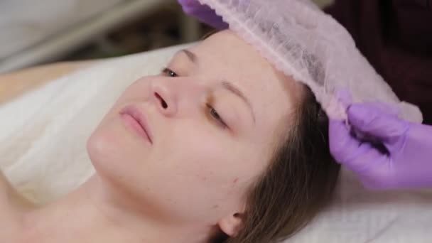 Профессиональный косметолог надевает шляпу на клиента женщине . — стоковое видео