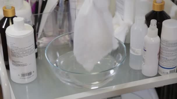 Un esteticista profesional humedece las toallitas en agua tibia para lavarte la cara. — Vídeos de Stock