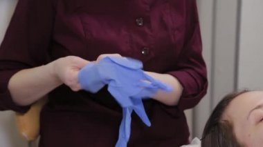 Profesyonel güzellik uzmanı ameliyattan önce lastik eldiven giyer..