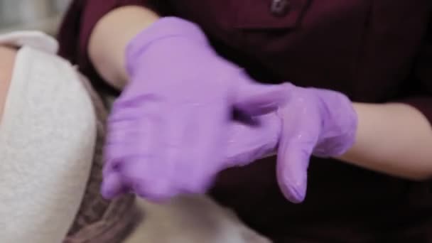 Profesionální kosmetička dává gel na rukavice a tře ho. — Stock video