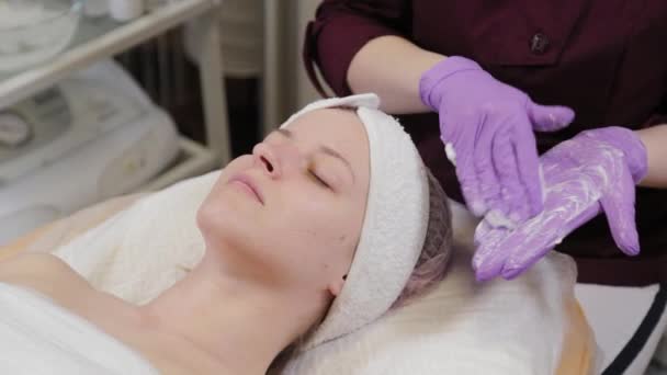 Esthéticienne professionnelle met du gel sur des gants et le frotte. — Video