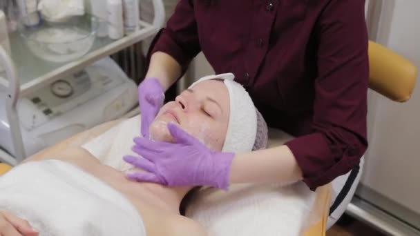 Estetista professionista lava una donna e massaggia il suo viso. — Video Stock