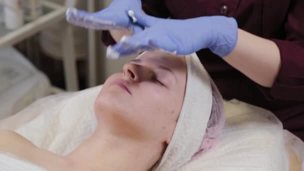 Esthéticienne professionnelle lave une femme et masse son visage. — Video