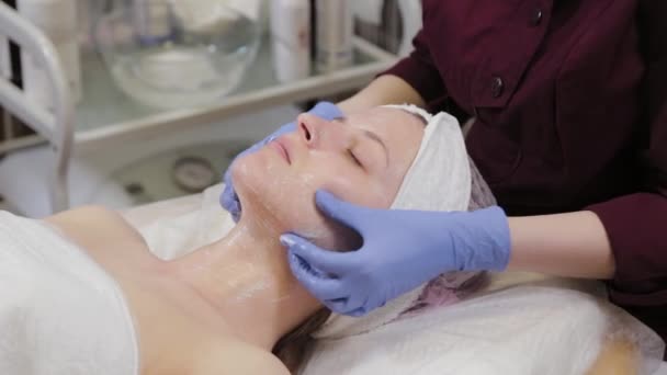 Professionelle Kosmetikerin wäscht eine Frau und massiert ihr Gesicht. — Stockvideo