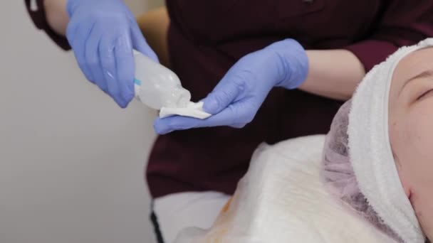 Professional cosmetologist treats cotton swab with tonic. — Stock Video