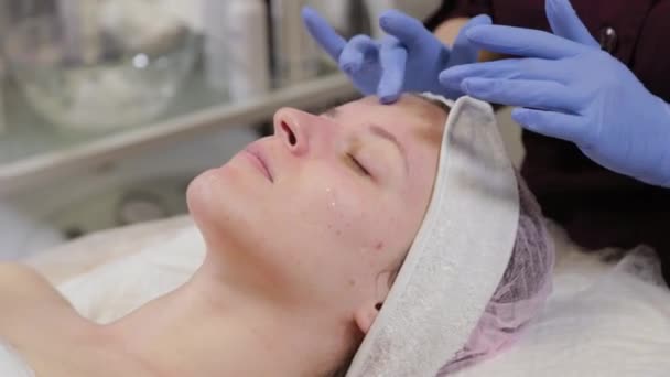 Un esthéticien professionnel fait un massage facial à une femme. Cosmétologie . — Video