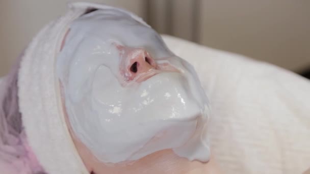 Mooie vrouw met een masker op haar gezicht in een schoonheidssalon. — Stockvideo