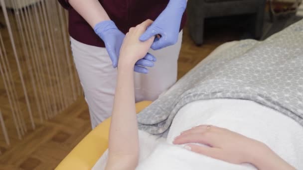 Профессиональный косметолог делает массаж ладоней во время процедуры . — стоковое видео