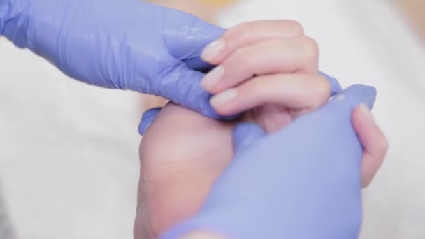 Professionelle Kosmetikerin führt Handflächenmassage während des Eingriffs durch.