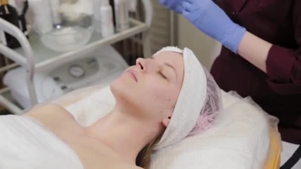 Estetista professionista lava la maschera dal viso di una donna. — Video Stock