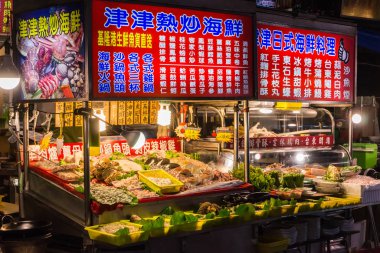 Taipei, Tayvan - 24 Aralık 2018: Wanhua 'nın en eski bölgesinde bulunan Guangzhou Caddesi Gece Pazarı' ndaki bir deniz ürünleri tezgahı misafirleri için çok çeşitli balık ve deniz ürünleri sunmaktadır..