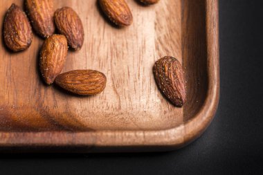 Bir kara tahta üzerinde ahşap sish kızarmış badem.