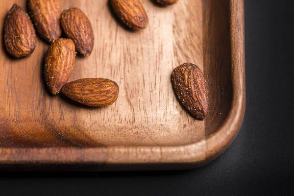 Bir kara tahta üzerinde ahşap sish kızarmış badem.
