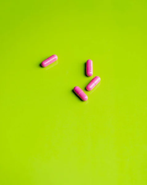 Pastillas de color rosa y la medicina sobre una mesa verde y backrgound . —  Fotos de Stock