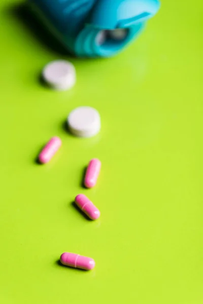 Pastillas de color rosa y la medicina sobre una mesa verde y backrgound . —  Fotos de Stock