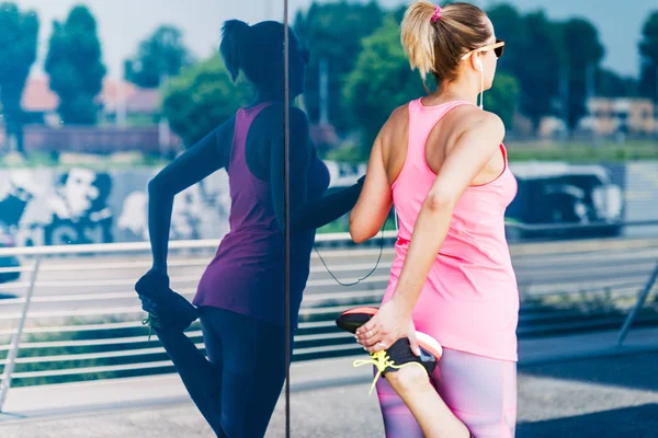 Young woman stretching after high intensity   training in an urb