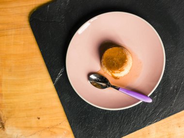 Börek - krem karamel masa örtüsü ile masa lambası sarı ahşap üzerinde pembe bir plaka üzerinde