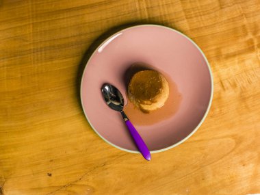 Börek - krem karamel masa örtüsü ile masa lambası sarı ahşap üzerinde pembe bir plaka üzerinde