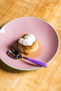Börek - bir tatlı muhallebi krem karamel krem üstüne bir geleneksel el yapımı el yapımı tablecoth üzerinde pembe bir tabakta ile