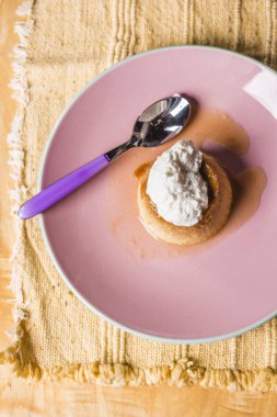 Börek - bir tatlı muhallebi krem karamel krem üstüne bir geleneksel el yapımı el yapımı tablecoth üzerinde pembe bir tabakta ile